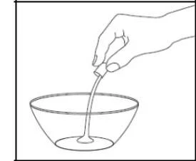 Una mano sujetando un pequeño envase del que fluye líquido directamente hacia un recipiente transparente colocado debajo