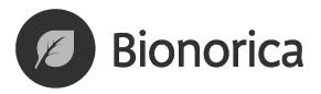 Logotipo de la empresa Bionorica que muestra una hoja de color gris claro situada dentro de un círculo oscuro junto al texto negro Bionorica