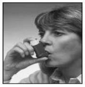 Una mujer sostiene el inhalador con la mano cerca de la boca, preparándose para tomar la dosis del medicamento, en un primer plano en blanco y negro del rostro y la mano