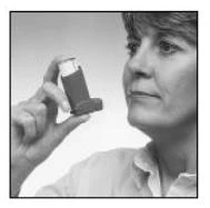 Una mujer sostiene un inhalador en posición vertical frente al rostro, mirando hacia el dispositivo, en una toma en blanco y negro