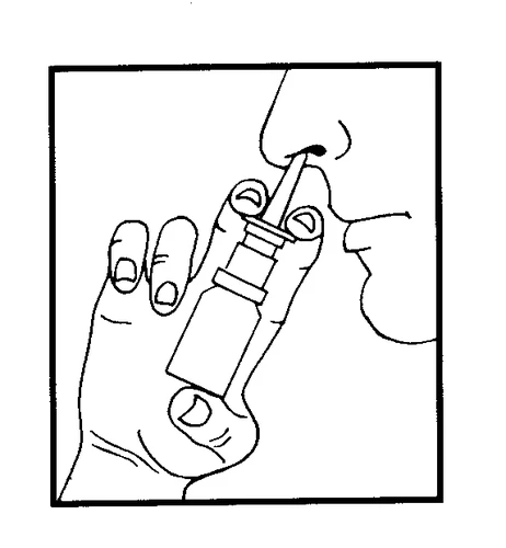Mano sujetando un pequeño frasco con dosificador, aplicando la punta del medicamento en la abertura nasal de una persona para administrar el fármaco
