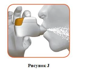 Hand holding an inhaler releasing aerosol into an open mouth for drug inhalation