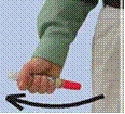 Una mano con manica verde impugna una siringa con tappo rosso, l'indice preme lo stantuffo, una freccia nera indica il movimento verso il basso a sinistra