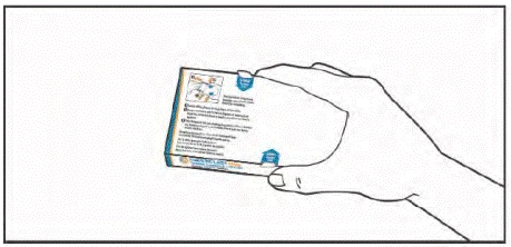 A hand holding a medicine box with the instruction leaflet visible, showing text, illustrations, and blue labels with information about usage