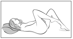 Woman lying on her back with knees raised, one leg bent at the knee and the other extended, head resting on a pillow, preparing for a medical procedure