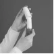 Mani che tengono un inalatore, con le dita che premono il pulsante per rilasciare la dose di farmaco, sfondo scuro, enfasi sull'uso corretto del dispositivo