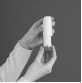 Mani tengono un inalatore bianco, le dita pronte a premere il pulsante per rilasciare una dose di farmaco
