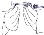 Hands holding a syringe, fingers pressing the plunger, needle pointing forward, preparation for injection
